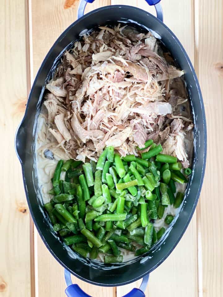 Shredded turkey and green beans added to large oval pot.