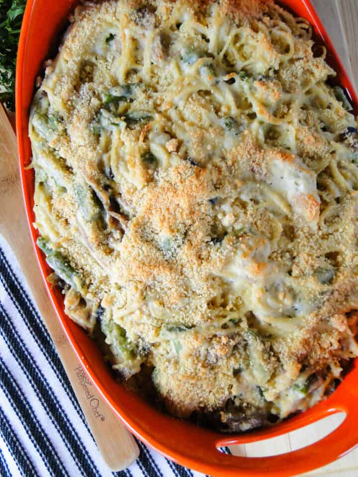 Top close up view of baked turkey tetrazzini in orange casserole dish.