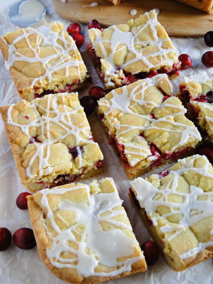 Cranberry bars sliced and in rows with a generous drizzle of glaze.