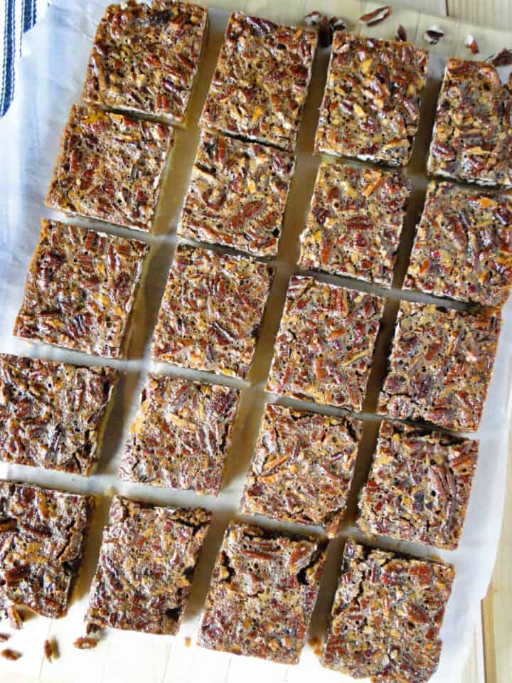 Top view of pecan pie bars in rows on a board.