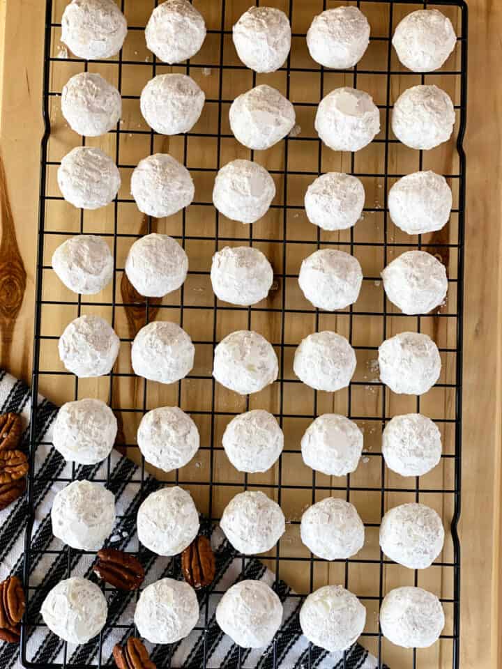 Russian tea cakes in rows on wire rack.