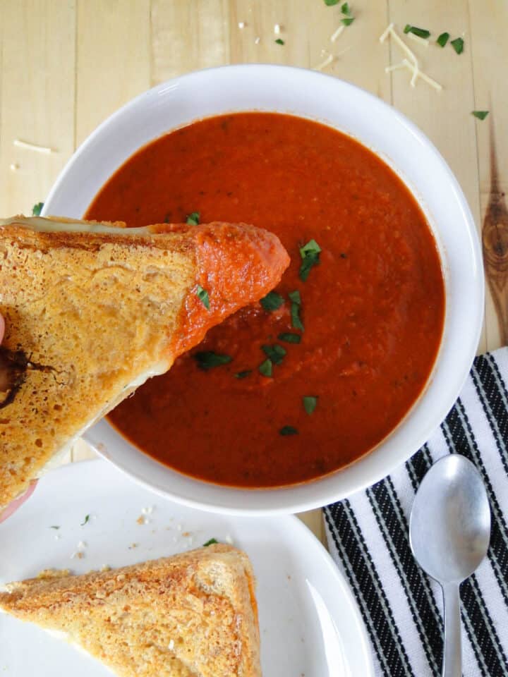 Grilled cheese dunked in bowl of easy tomato soup.