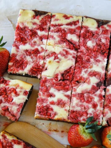 Strawberry cheesecakes brownies sliced and on board.
