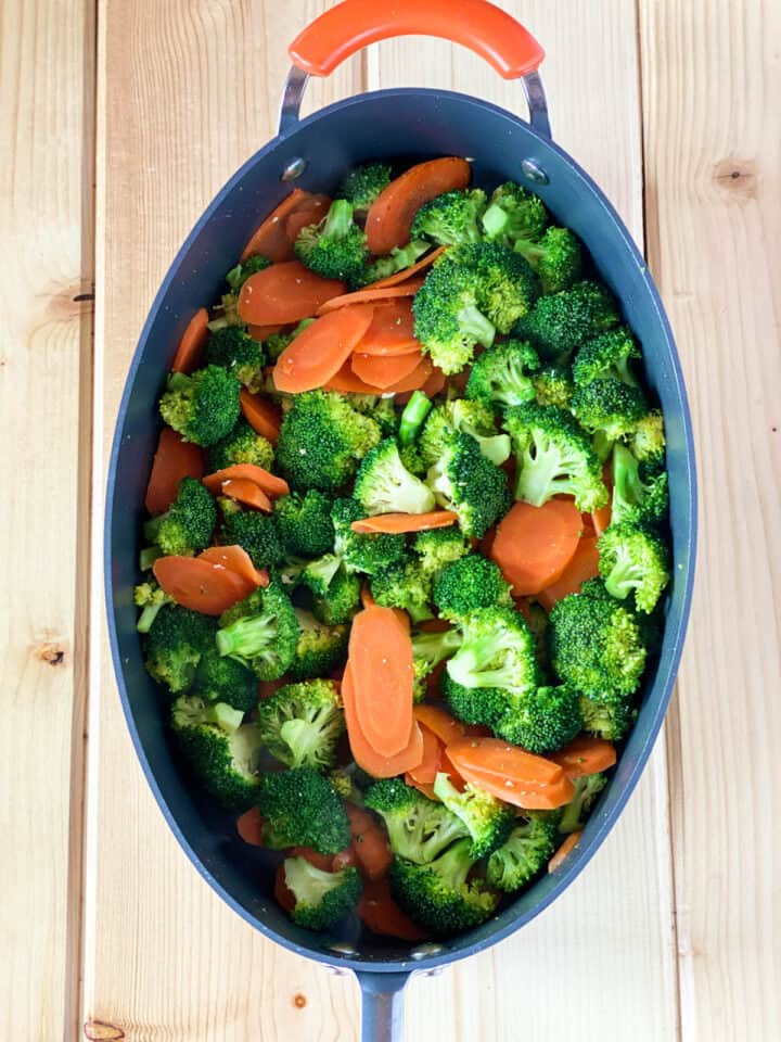 Broccoli florets added to carrots in large skillet.