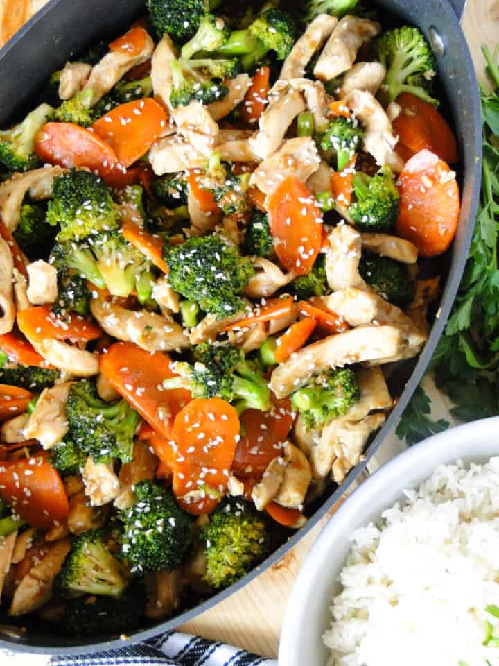 Large skillet full of chicken and broccoli stir fry.