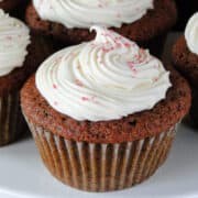 Close up of dye free red velvet cupcakes with cream cheese frosting swirled on top.