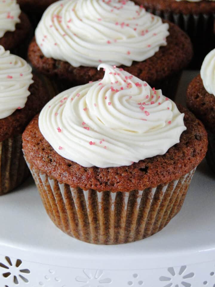 Close up of dye free red velvet cupcakes with cream cheese frosting swirled on top.