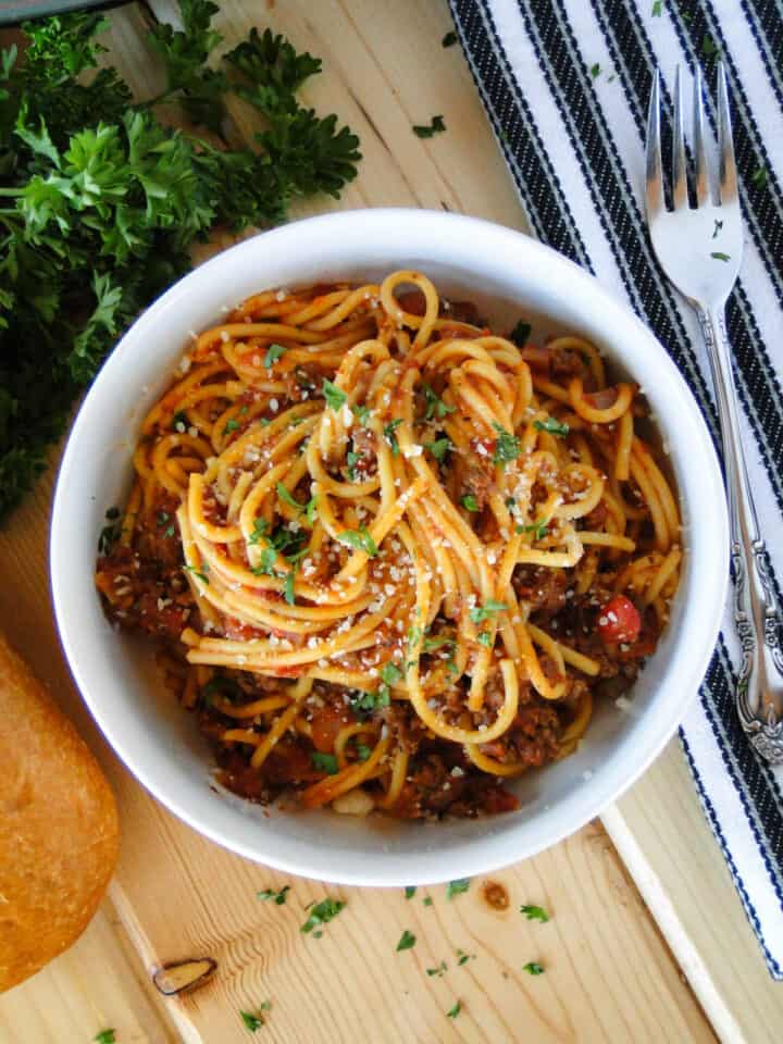 Top view of Instant pot spaghetti and meat sauce in white round bowl.