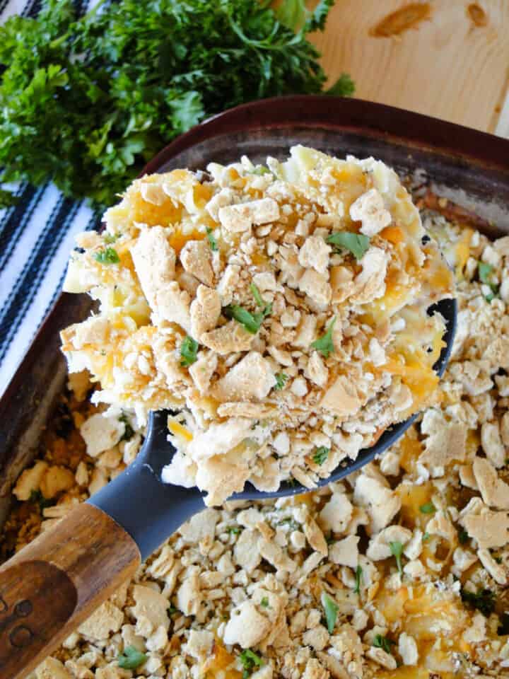 Cheesy tuna noodle casserole being served out of casserole dish.