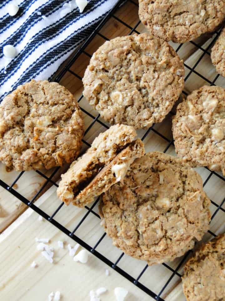 Cookies on cooling rack with one cookie broken in half showing center of cookie.