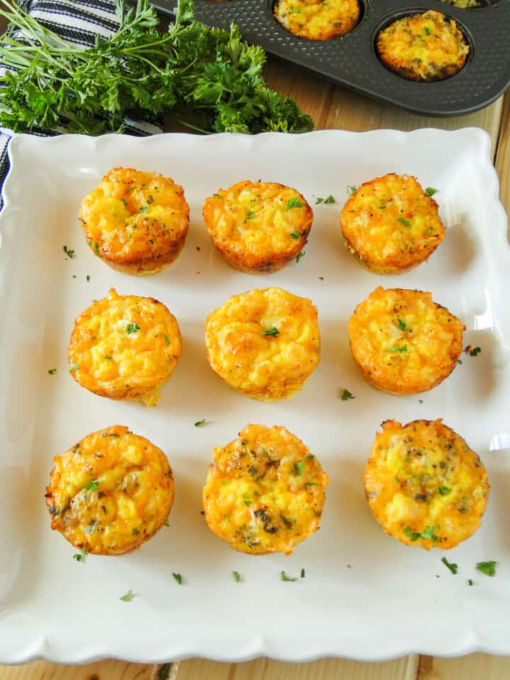 Ham and cheese mini frittatas in rows on square white platter.