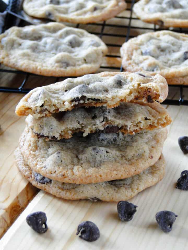 Classic chocolate chip cookies stacked with one broken in half.
