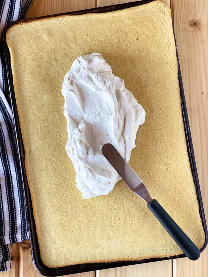 Frosting in center of baked cake in sheet pan.