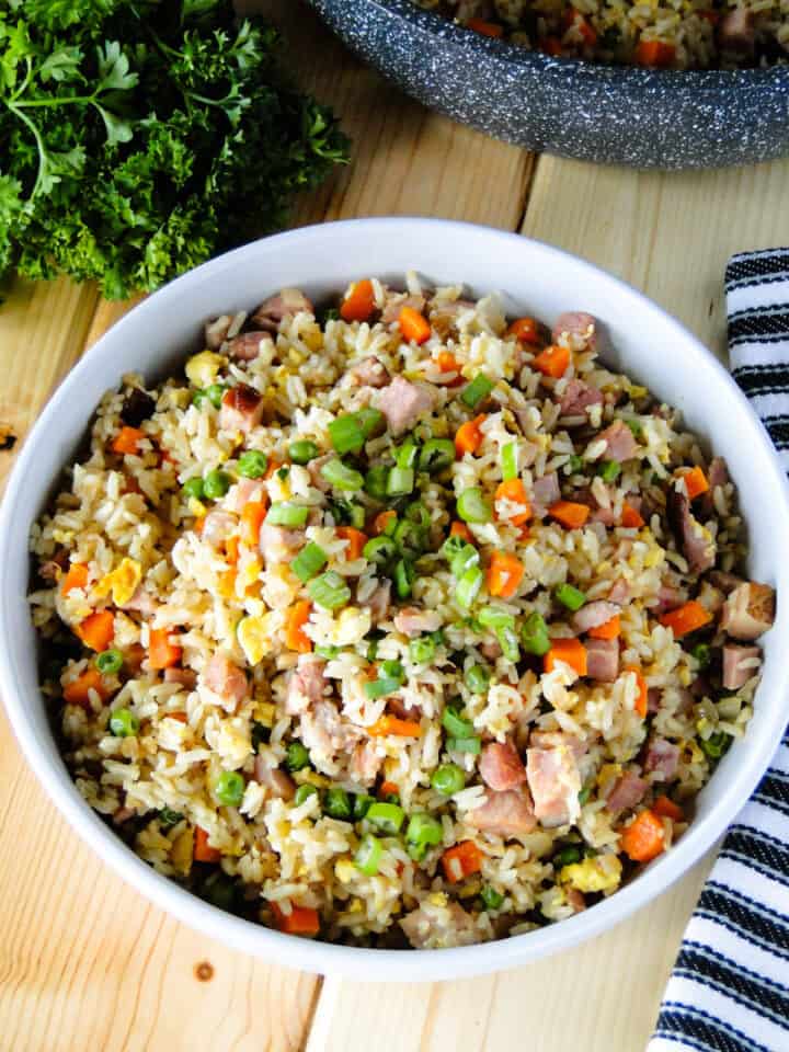 Ham fried rice in white round serving bowl.