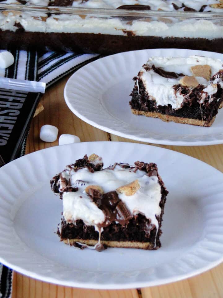 S'mores brownie slices on white round plates.