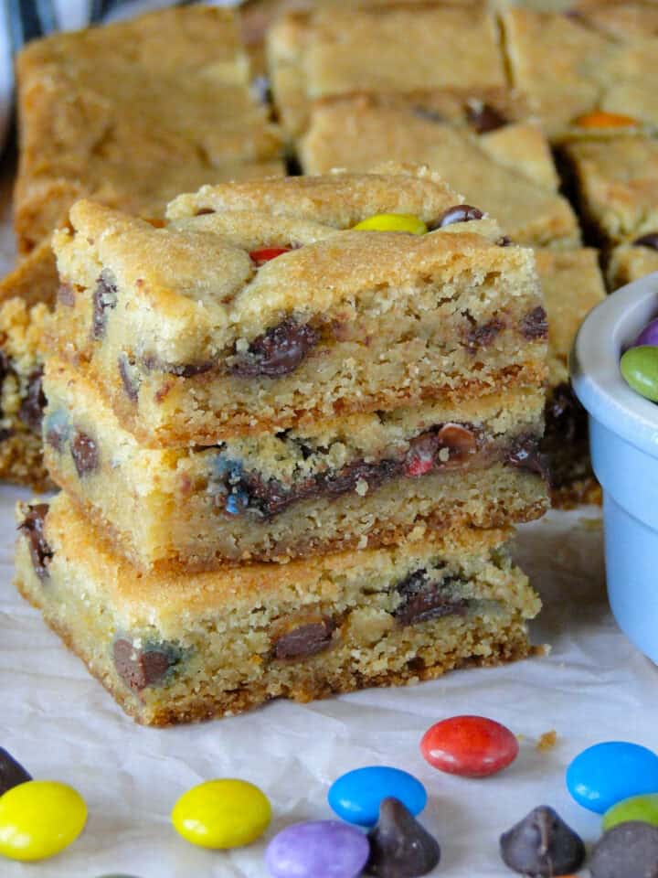 Three chocolate chip cookie bars stacked showing chewy and chocolatey centers.