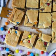 Top view of chocolate chip cookie bars with spatula and extra candies.