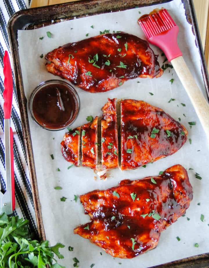 Top view of three Oven roasted BBQ chicken breasts of sheet pan.