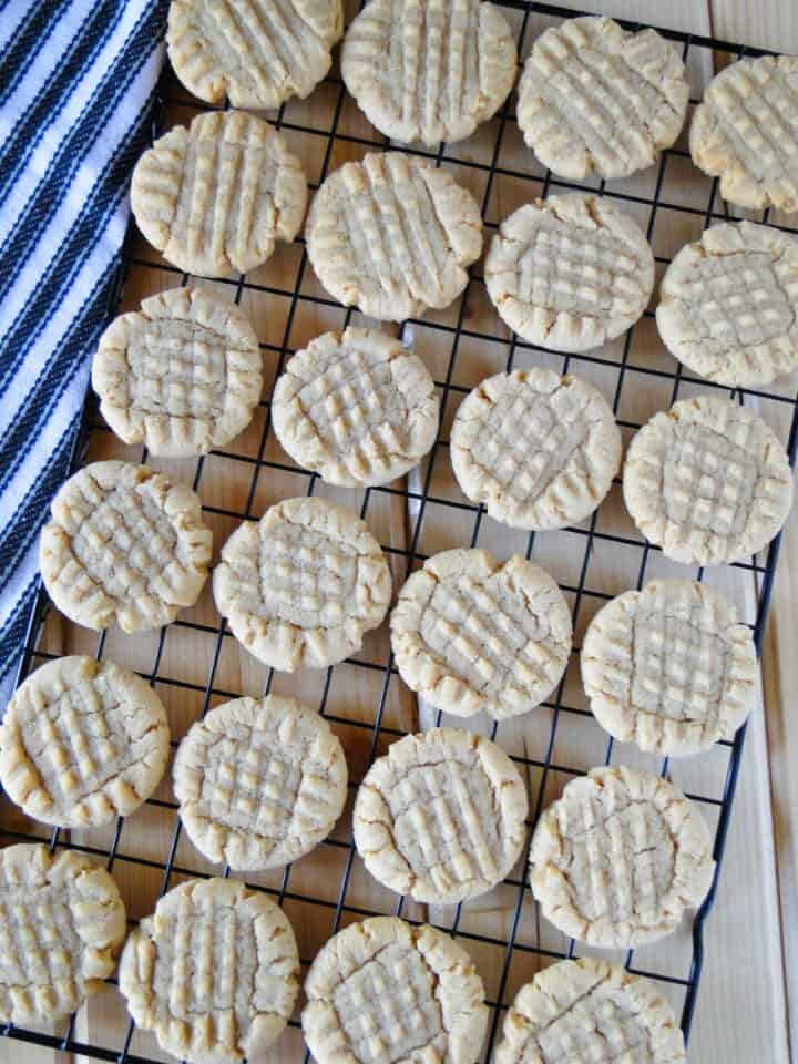 Old fashioned peanut butter cookies in rows on wire rack.