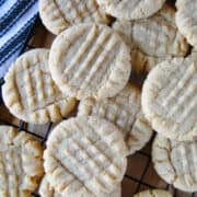 Old fashioned peanut butter cookies piled on wire rack.
