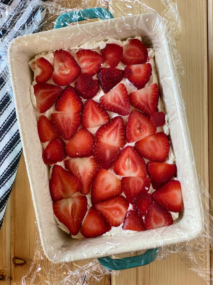 Sliced strawberries added on top of cream.