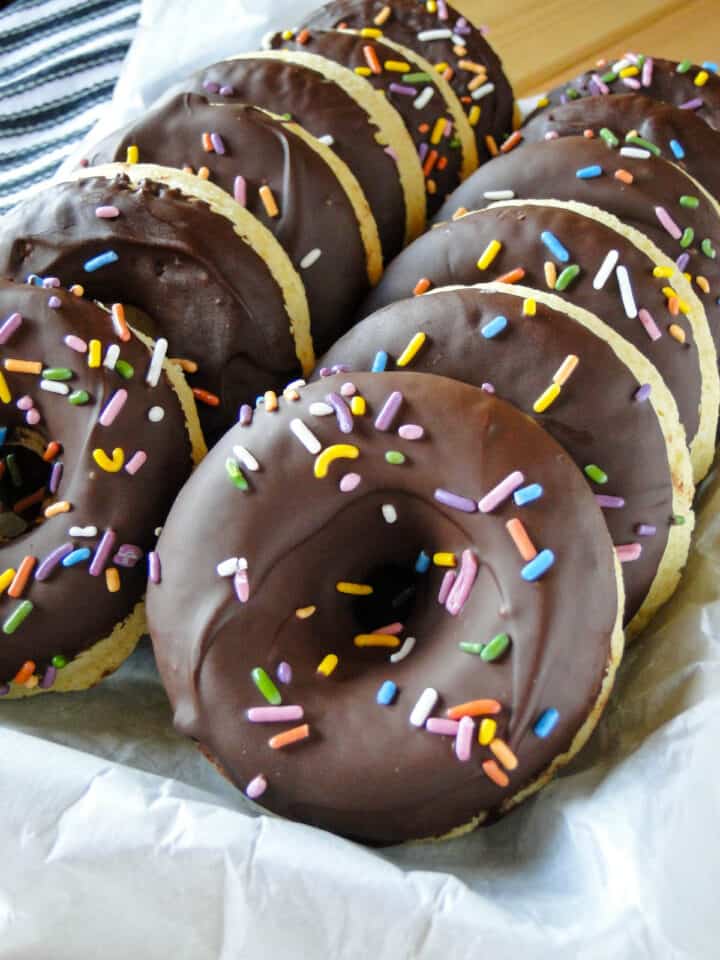 Close up view of baked cake donuts with chocolate glaze and sprinkles.