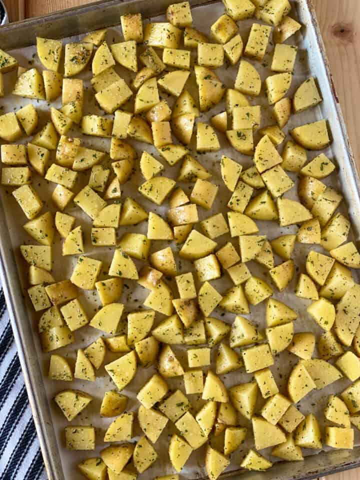 Prepared cubed potatoes on sheet pan.