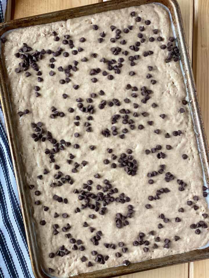 Pancake batter in sheet pan topped with mini chocolate chips.