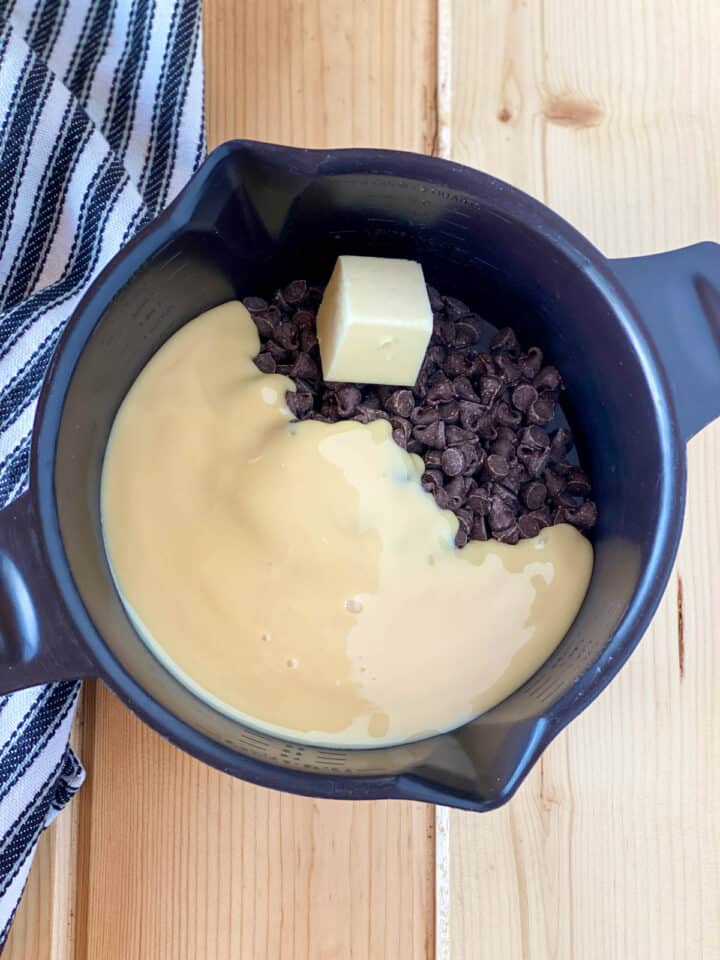 Chocolate fudge ingredients in black microwave safe bowl.