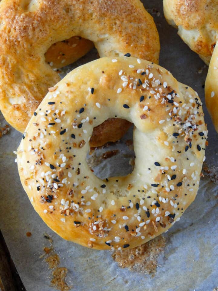 Close up view of bagel topped with everything bagel seasoning and layered on top of another bagel.