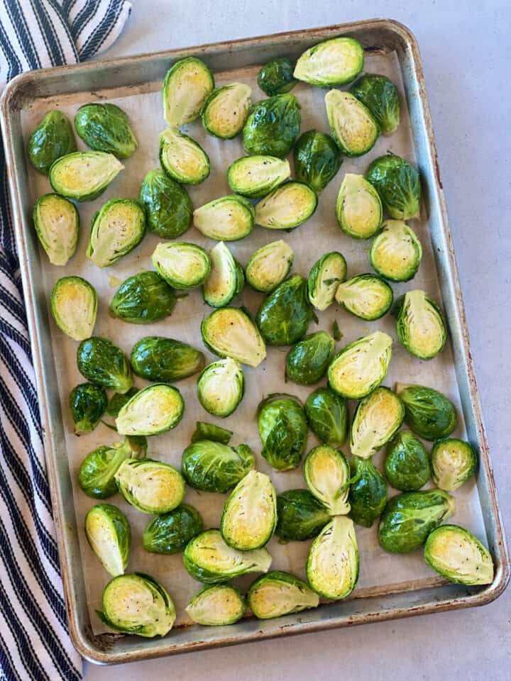 Brussels sprouts prepared and in single layer on sheet pan with parchment paper.