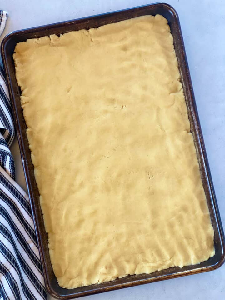 Cookie bar dough pressed into sheet pan.