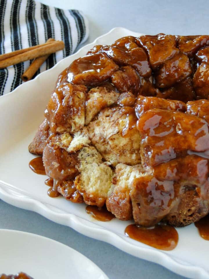 Monkey bread on white square platter with pieces pulled off.