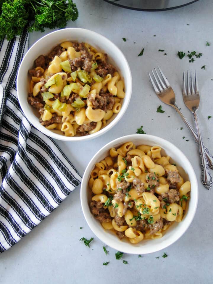 Instant pot hamburger helper in two white round bowls with two forks on the side.