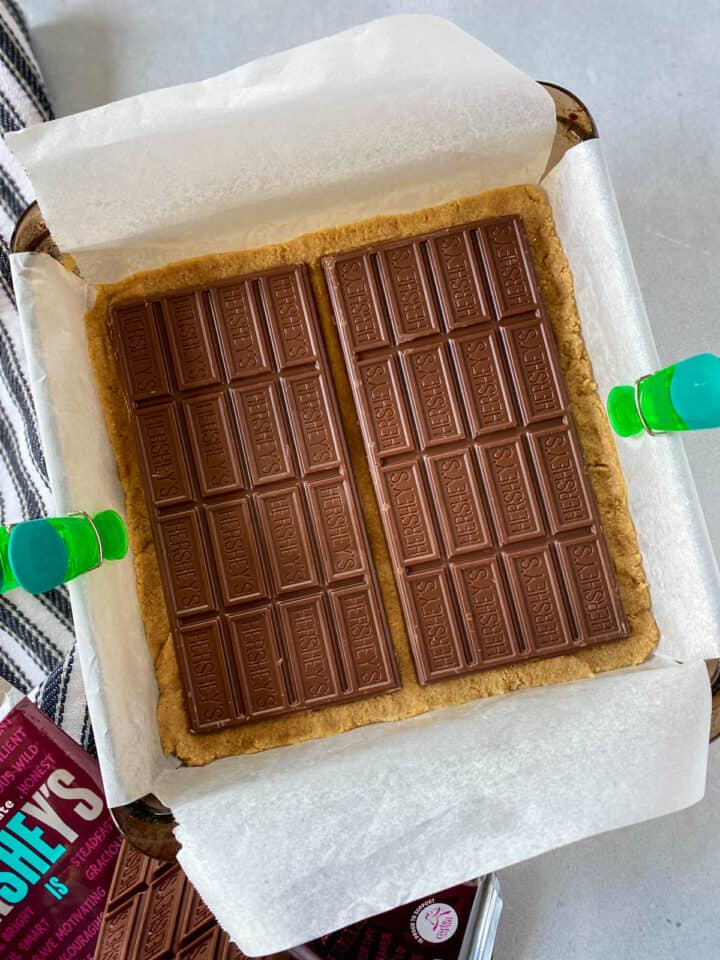 Chocolate bars placed on top of cookie dough bottom.