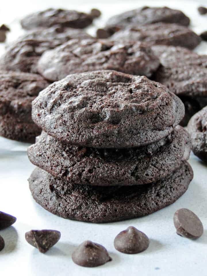Side view of three double dark chocolate chip cookies stacked.