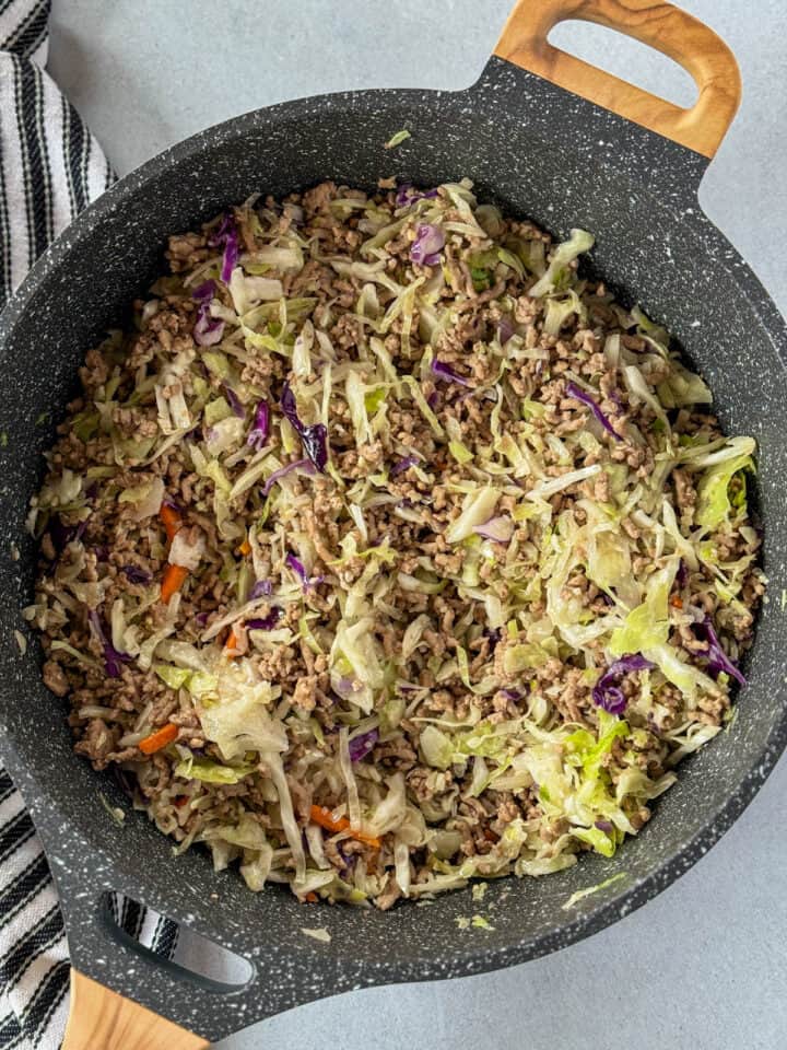 Cole slaw mix added to meat mixture in large skillet.
