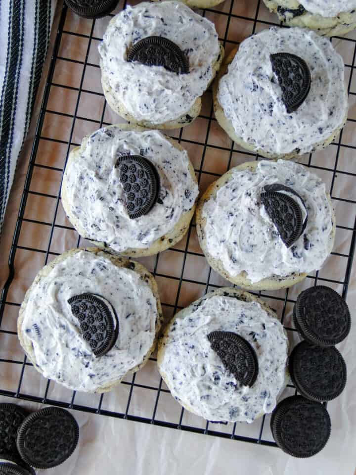 Top view of frosted cookies and cream cookies on wire rack.