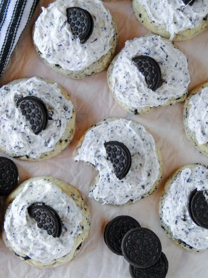 Top view of frosted cookies and cream cookies with bite taken out of middle cookie.