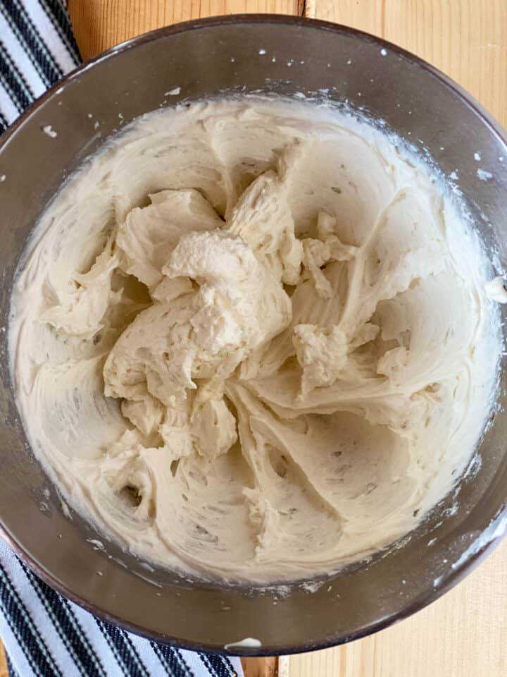 Buttercream frosting mixed together in large mixing bowl.