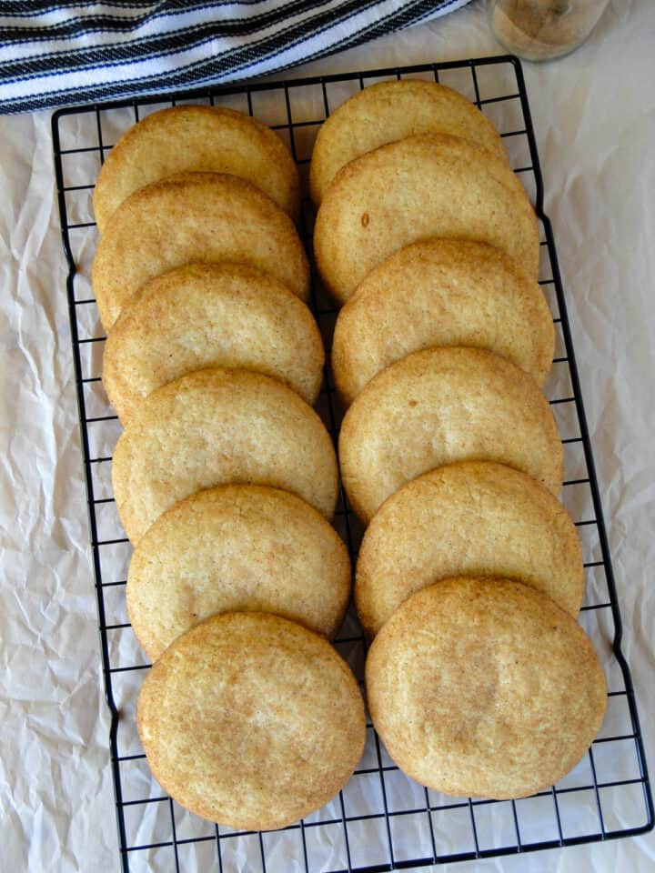 Top view of gourmet snickerdoodle cookies layered in two columns on wire rack.