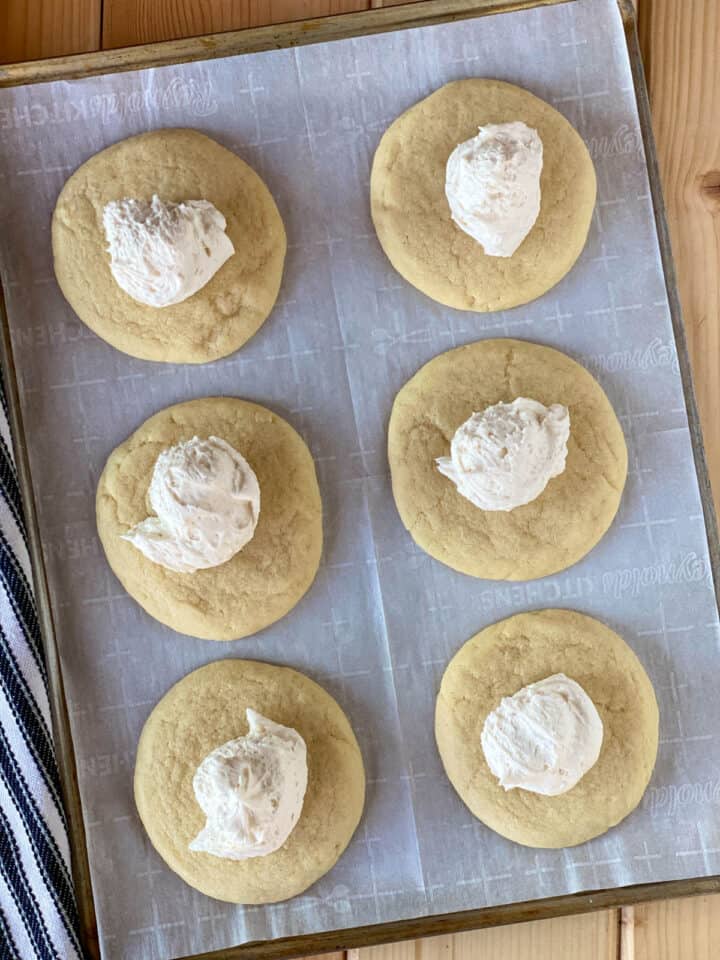 Frosting dolloped on top of cookies.