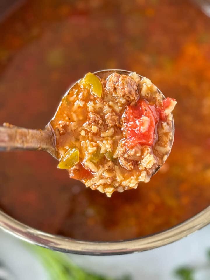 Instant pot stuffed pepper soup being ladled out of instant pot.