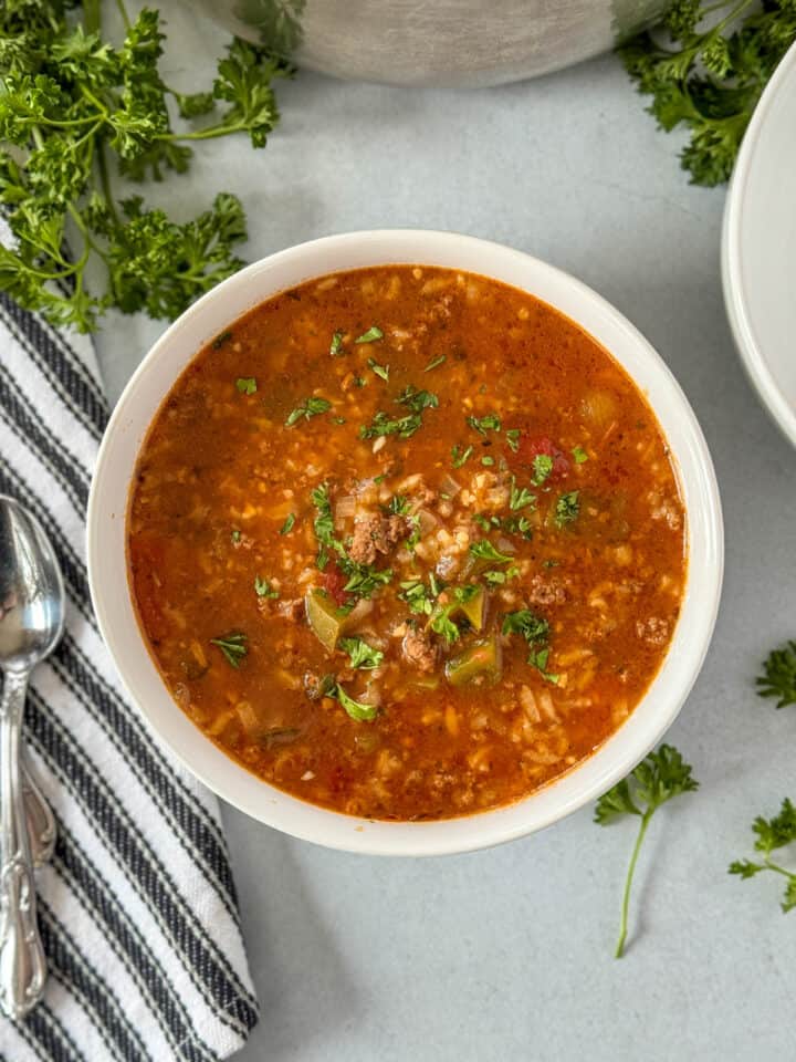 Top view of instant pot stuffed pepper soup in white round bowl with spoon on the side.