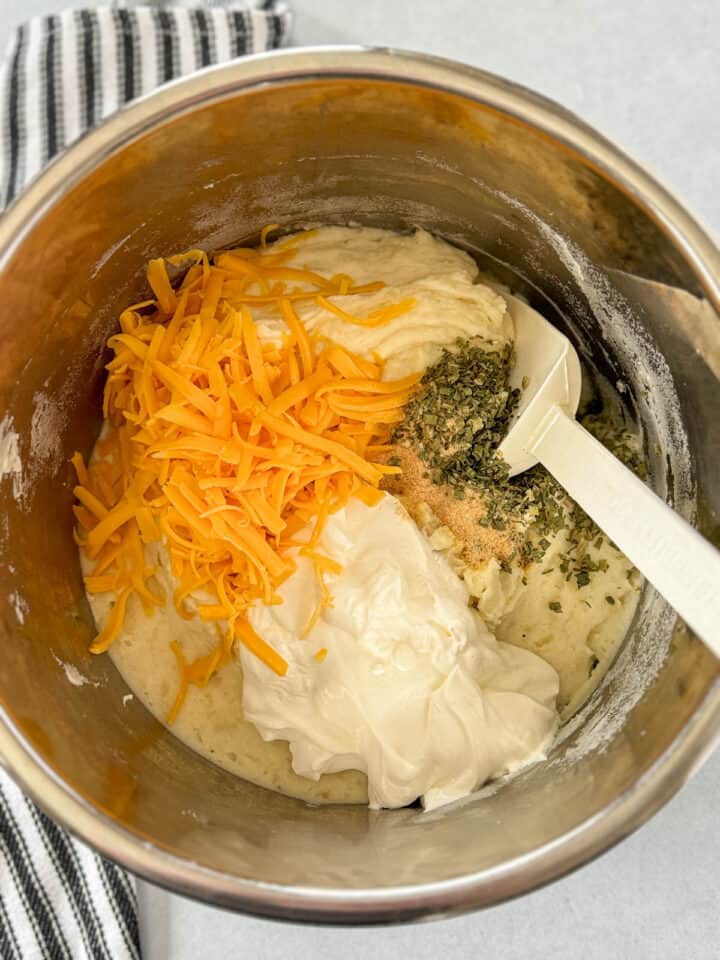 Milk, sour cream, shredded cheese, and seasonings added to mashed potatoes.