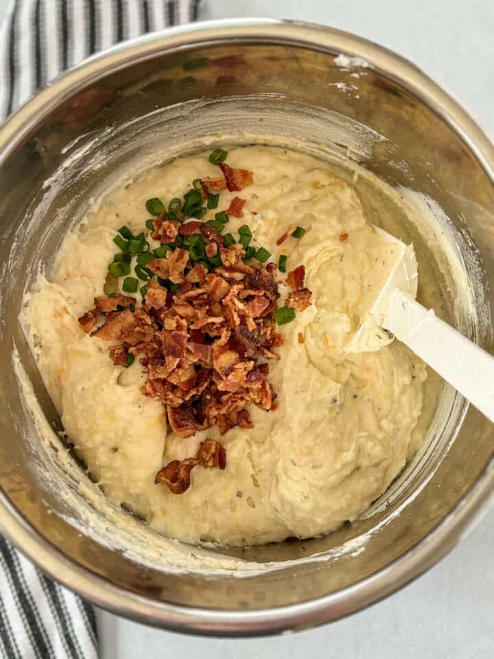 Crumbled bacon and green onions added to mashed potatoes in instant pot.