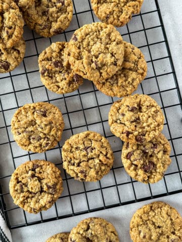 Oatmeal chocolate chip cookies on wire rack.