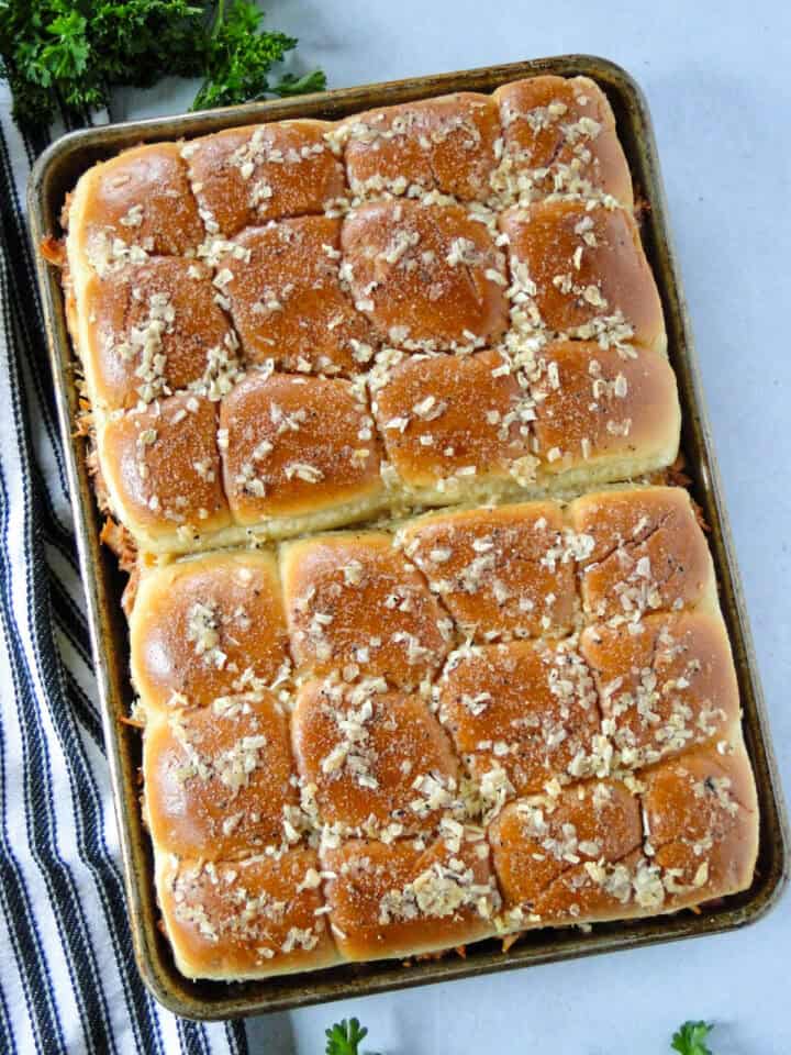 Top view of bbq chicken sliders baked in sheet pan.