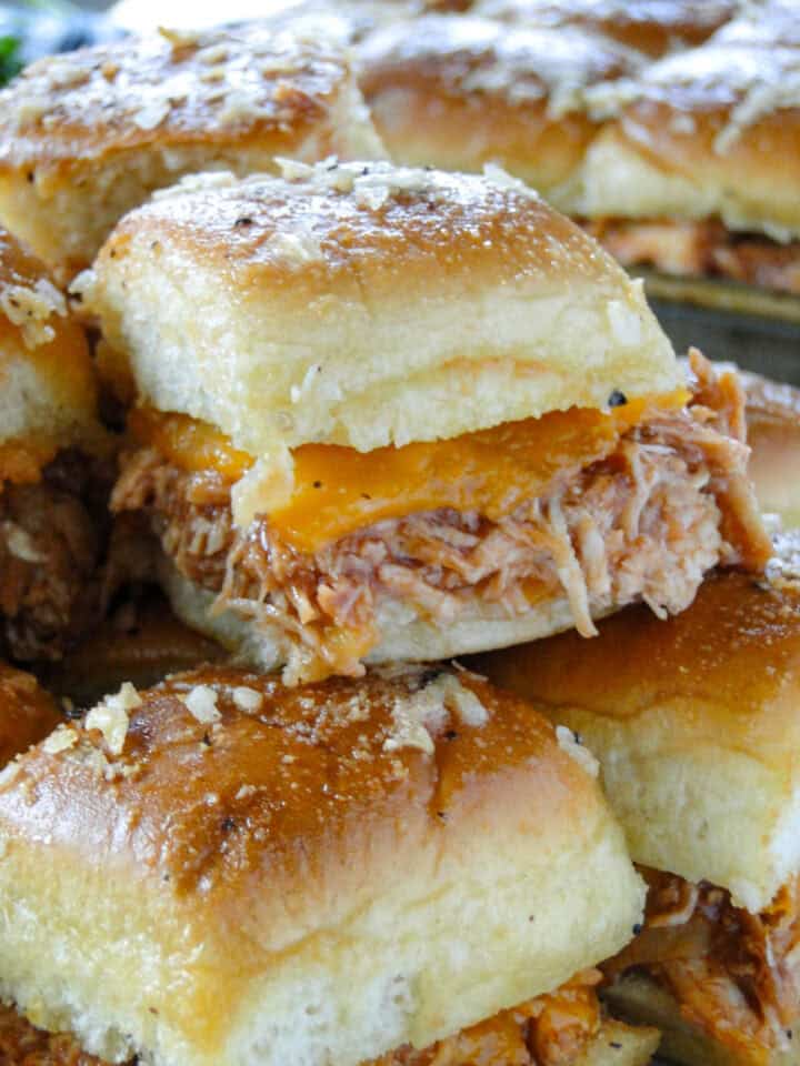 Close up side view of bbq chicken slider on top of other sliders.