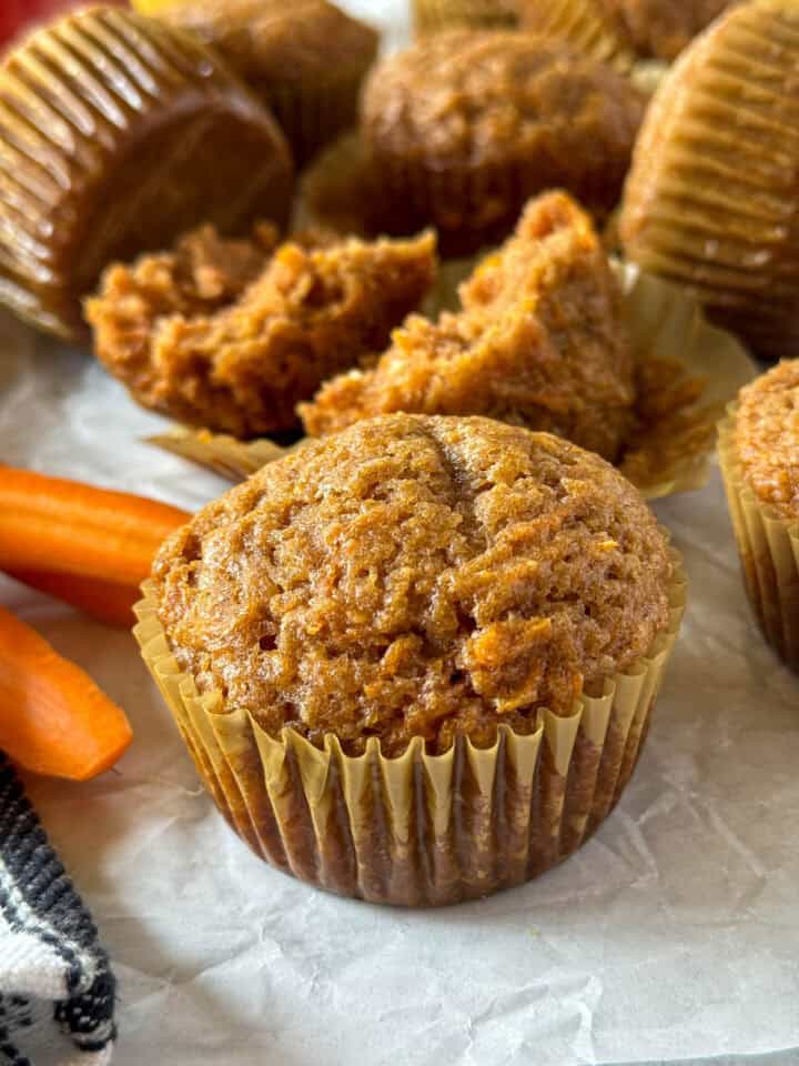 Side view of applesauce carrot breakfast muffin in front of more muffins.